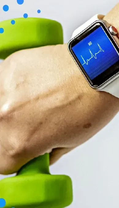 Hand holding a green dumbbell while wearing a smartwatch